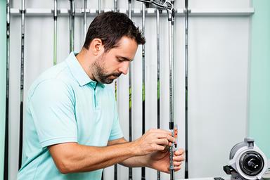 Iriv Eisenberger, golf fitter, measuring a club in a bright fitting area
